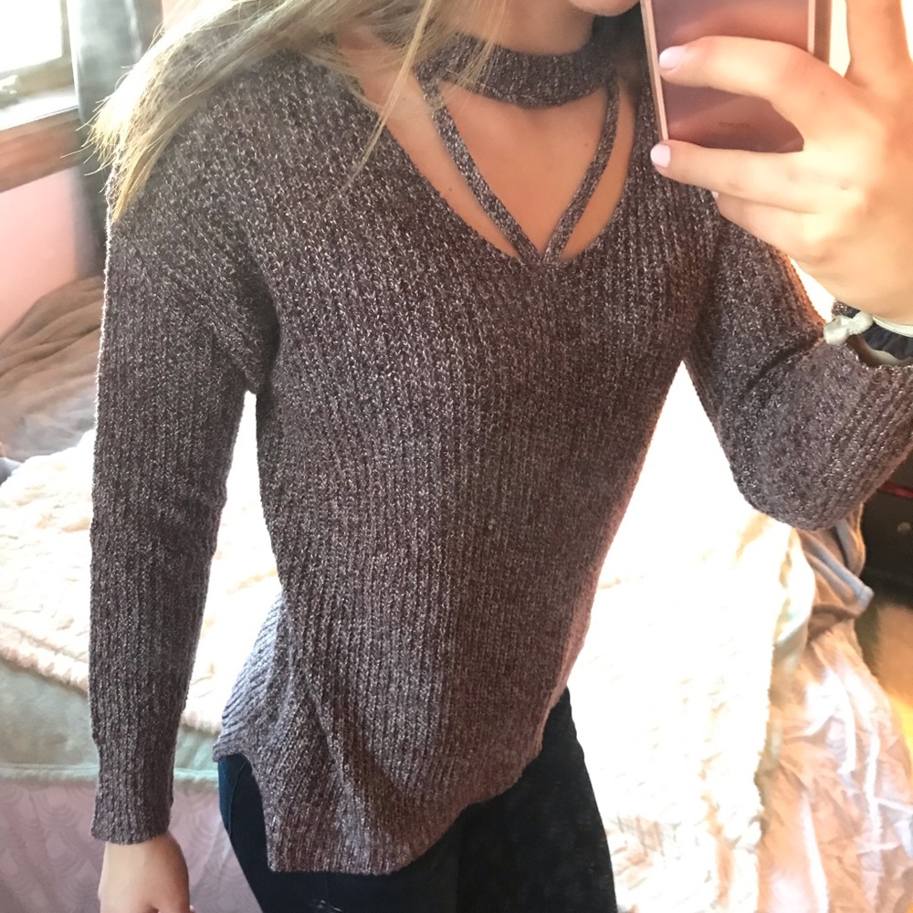 Maroon/white sweater with neck cut outs.